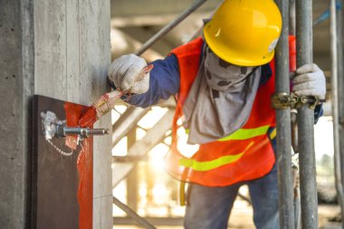 İnşaat alanında fırça ve paslı koruma boyasıyla el.