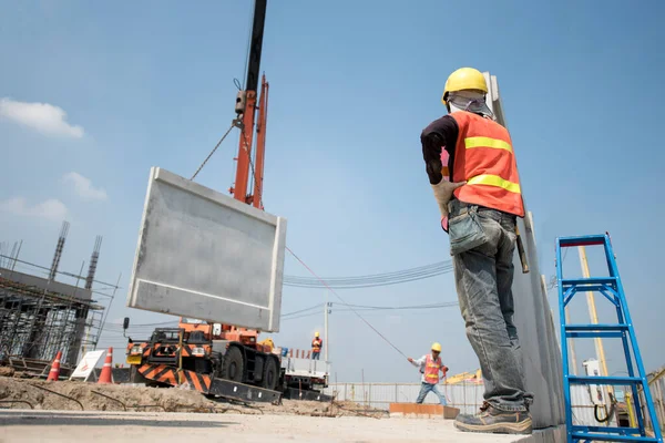 新建筑库区的建筑工人及工程师寻找流动起重机升降电梯预制板混凝土墙 — 图库照片