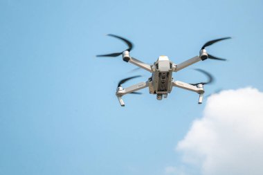 Mavi gökyüzünde uçan modern insansız hava aracının düşük açılı görüntüsü