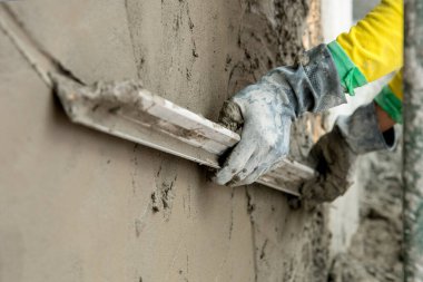 Duvara yapışkan kaplama uygulayan işçilerin yakın plan görüntüsü       