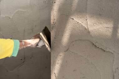 Duvara yapışkan kaplama uygulayan işçilerin yakın plan görüntüsü       