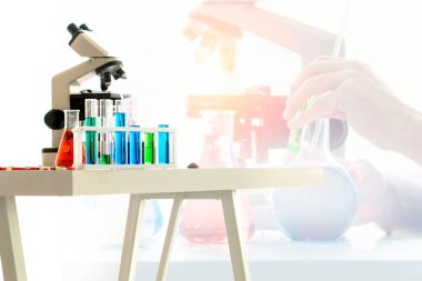 Laboratuvar mikroskobu ve test tüpleri masada, yakın plan. Laboratuvar camları..