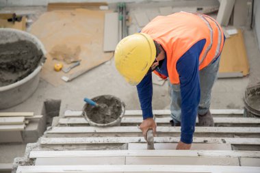 İnşaat işçisi güvenlik üniforması montajı seramik zemin giyiyor