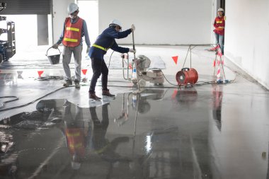 İnşaat işçisi epoksi döşeme ya da zemin sertleştiricisi boyuyor