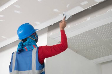 İnşaat işçisi tavan sıva işi yapıyor.