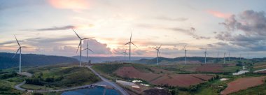 Rüzgâr türbininden hava manzarası. Tarlada inşaat, dağda çayır. Güzel mavi gökyüzü güneşli.