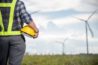 İş adamı veya elektrik mühendisi rüzgar türbini enerji tasarrufu kavramını kontrol ediyor 