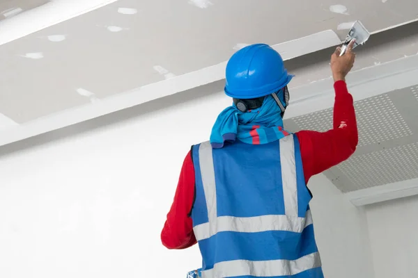 İnşaat işçisi tavan sıva işi yapıyor.