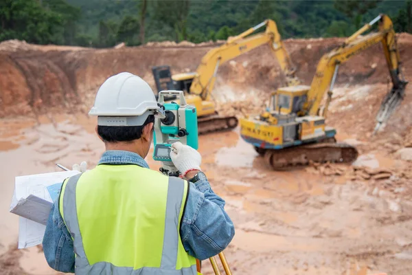 建設現場の測量技術者がテオドライトチェック掘削基礎工事を使用 — ストック写真