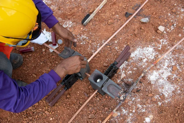 Bakır topraklama yıldırım koruma sistemini bağlayın. İnşaat alanında bakır toprak kablosu kaynaklanıyor.