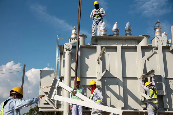 Electrical engineering teamwork installation transformer at power plant construction site