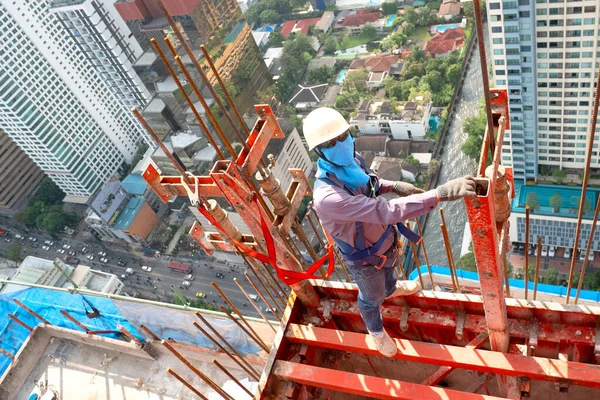 Bauarbeiter Tragen Persönliche Schutzausrüstung Und Demontieren Stahlkonstruktion Bei Hochhaus Bauprojekt lizenzfreie Stockfotos