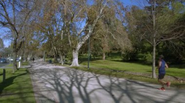 Parkta yürüyüş pistinde koşan bir adam.