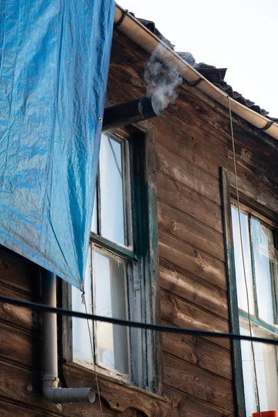 Ahşap bir evin bacasından duman çıkıyor.