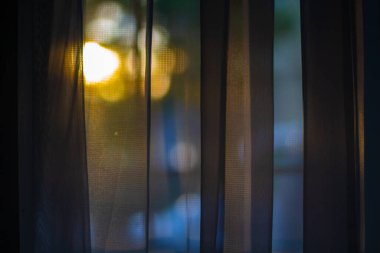 Evin perdesinin arkasından gün batımı.