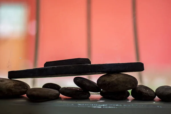 Row of stones and flower standing in front of window