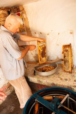Arı yetiştiricisi arılarla ve arı kovanlarıyla çalışıyor..