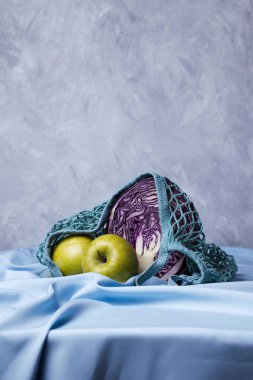 Sıfır atık torbasında organik yeşil elma ve kırmızı lahana, seçici odaklanma