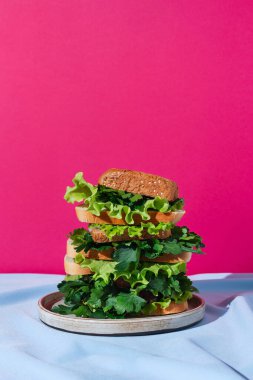 Örtünün üzerinde çeşitli yeşillikler olan bir yığın farklı ekmek, sağlıklı sandviç konsepti, seçici odaklanma