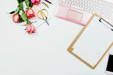 Pembe dizüstü bilgisayarlı düz çerçeve düzenleme, güller ve beyaz üzerine diğer aksesuarlar. Kadınsal iş modeli, kopyalama alanı