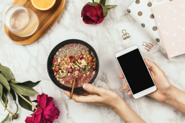 Not defteri ve akıllı telefon ile kadın eli düz çizgi, chia pudingli vegan meyve suyu kasesi, sağlıklı kahvaltı konsepti