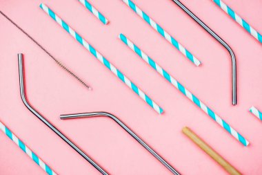 İçecekler için sürdürülebilir çeşitli ekolojik pipetlerin düzlüğü: Pembe üzerine özel fırçası olan kağıt, metal ve bambu, sıfır atık yaşam tarzı kavramı