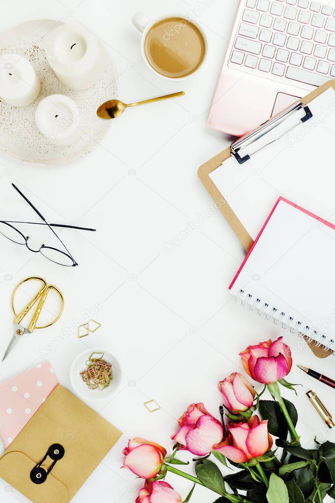 Flatlay frame arrangement with pink laptop, candles, roses, glasses and other accessories on white. Feminine business mockup, copyspace