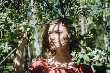 Bahar ya da yaz portresi çiçek açan bahar ağaçlarında genç beyaz kadın, seçici odaklanma