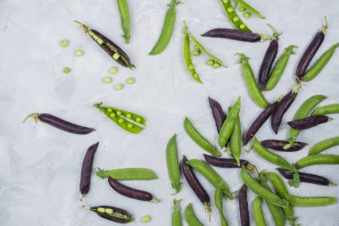 Yeşil ve organik çiftçilerin yassı çimento arka planında mor bezelye kabukları