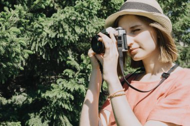 Klasik film kamerası olan genç bir kadının güzel bir yaşam tarzı portresi. Kadın fotoğrafçı ya da dışarıda bir turist. Seçici bir odak noktası.