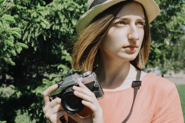 Klasik film kamerası olan genç bir kadının güzel bir yaşam tarzı portresi. Kadın fotoğrafçı ya da dışarıda bir turist. Seçici bir odak noktası.