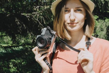 Klasik film kamerası olan genç bir kadının güzel bir yaşam tarzı portresi. Kadın fotoğrafçı ya da dışarıda bir turist. Seçici bir odak noktası.