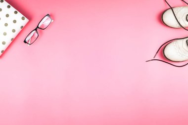 Pembe arka planda beyaz ayakkabılı, planlamacı ve gözlüklü düz yatak. İşçilik ya da moda konsepti. Kopyalama alanı