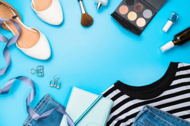 Düz ayakkabılı, düz ayakkabılı, kozmetik ürünlü, planlamacı, kot pantolonlu, üstsüz ve diğer aksesuarlı. Kopyalama alanı, mavi arkaplan