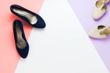 Modaya uygun mavi ve gri topuklu ayakkabılı Pastel moda düz yatak düzenlemesi. Kendini hazırlama ya da giydirme kavramı. Mor, pembe ve beyaz arkaplan.