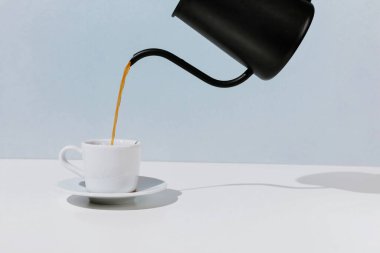 Kahve siyah metal çaydanlıktan, beyaz bardaktan, seçici odak