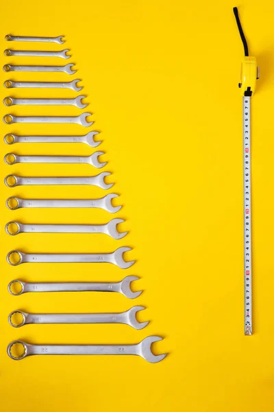 Jeu d'outils de clé et ruban à mesurer sur fond jaune — Photo