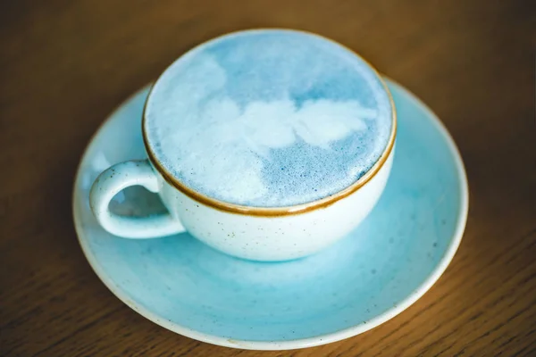 Trendy blue matcha tea latte in a cup.