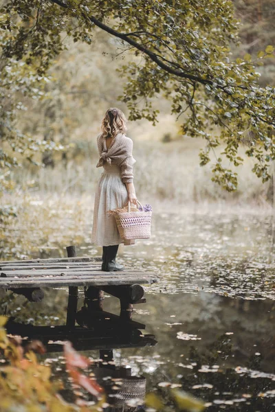 Belle femme debout sur la jetée et regardant la nature dans la forêt d'automne . — Photo