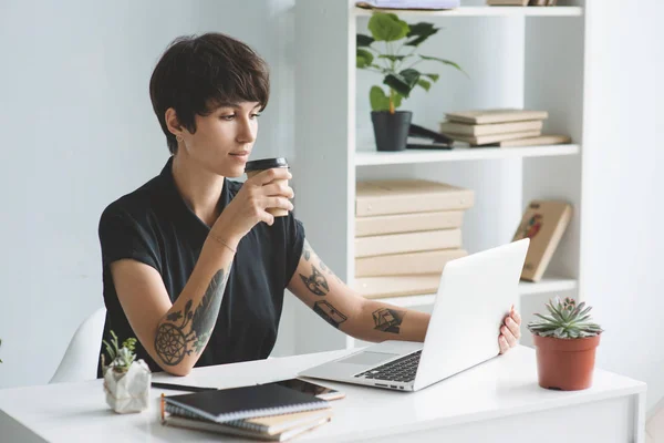 Geschäftsfrau arbeitet mit Laptop und trinkt Kaffee — Stockfoto