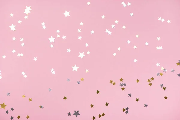 Golden stars glitter on trendy pink pastel background.