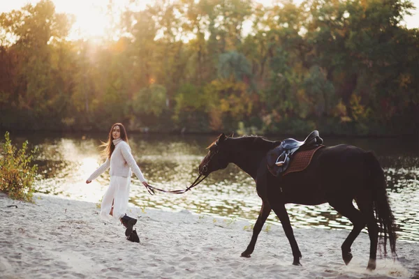 Bella donna a piedi con cavallo vicino al fiume — Foto Stock