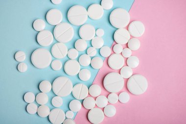 Çeşitli beyaz hap mavi ve pembe arka plan üzerinde yukarıdan