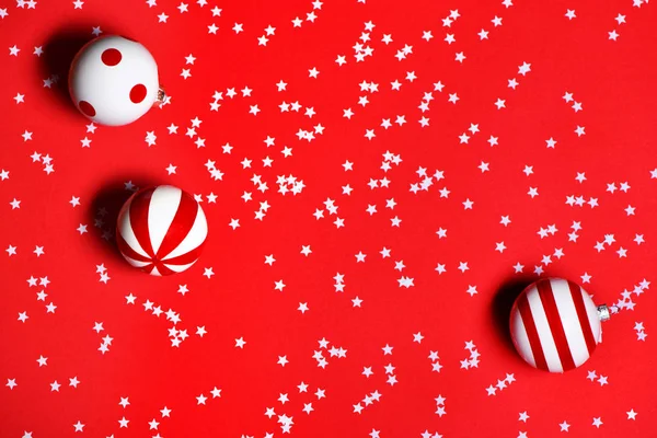 Christmas toys with confetti on red background. — Stock Photo, Image