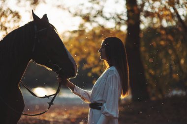 Güzel bir kadınla at arka ışık içinde