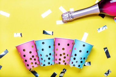 Sarı arka plan üzerinde mavi ve pembe polka nokta kağıt bardak.