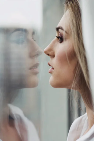 Bella donna guardando il suo riflesso nella finestra . — Foto Stock