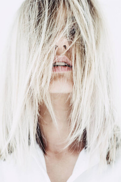 Close up portrait of beautiful woman with blonde hair covering her face