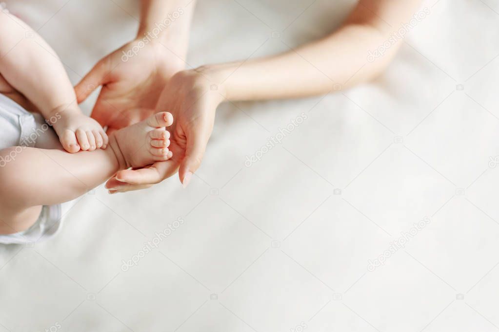 Newborn feet in mothers hands. Mother and her child concept. Copy space.