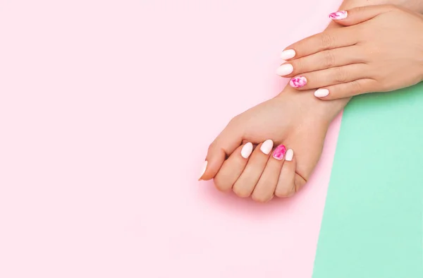 Manicura perfecta con arte de uñas de moda sobre fondo rosa y turquesa — Foto de Stock